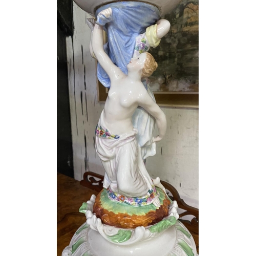 231 - A LARGE PORCELAIN COMPOTE CENTREPIECE, with flower encrusted basket, female figures to column standi... 