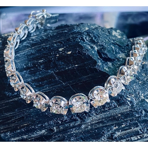 35 - A CLASSIC 18CT WHITE GOLD TENNIS BRACELET, claw set with 10.00cts of brilliant cut diamonds, colour:... 