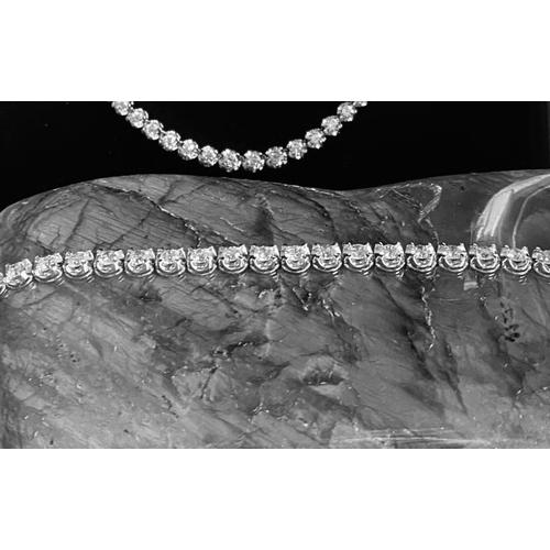 35 - A CLASSIC 18CT WHITE GOLD TENNIS BRACELET, claw set with 10.00cts of brilliant cut diamonds, colour:... 