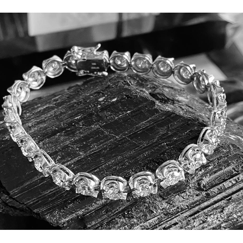 35 - A CLASSIC 18CT WHITE GOLD TENNIS BRACELET, claw set with 10.00cts of brilliant cut diamonds, colour:... 