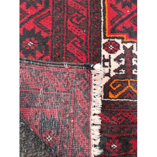 43 - A GOOD QUALITY PERSIAN MASHAD BELOUCH FLOOR RUG, over all ground colour red, with highlights in must... 