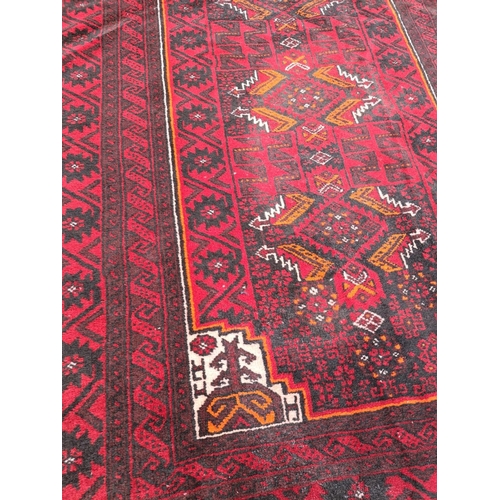 43 - A GOOD QUALITY PERSIAN MASHAD BELOUCH FLOOR RUG, over all ground colour red, with highlights in must... 