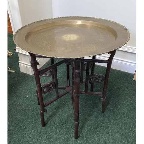 50 - AN ANTIQUE ANGLO/INDIAN FOLDING SIDE TABLE, brass embossed shaped circular top, with character mark ... 