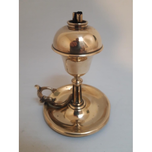 55 - AN UNUSUAL VICTORIAN POLISHED BRASS OIL BURNER CHAMBERSTICK LAMP, with circular base and scroll thum... 