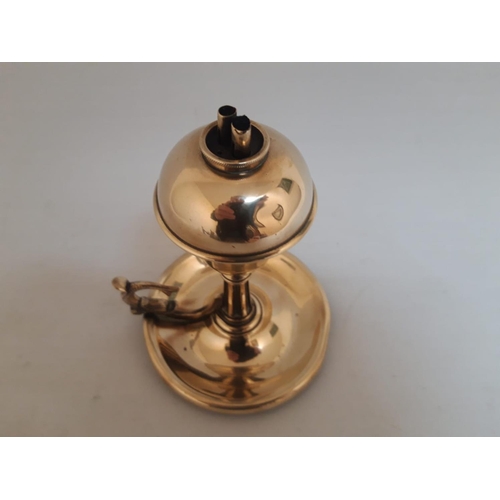 55 - AN UNUSUAL VICTORIAN POLISHED BRASS OIL BURNER CHAMBERSTICK LAMP, with circular base and scroll thum... 