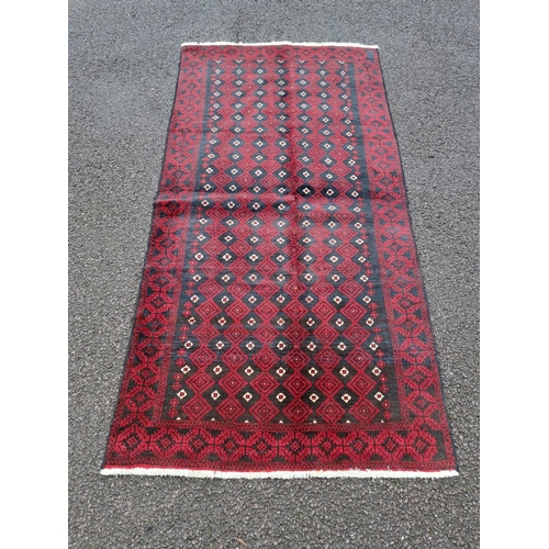 63 - A VERY GOOD QUALITY PERSIAN MASHAD BELOUCH FLOOR RUG, with a repeat diamond motif to the centre surr... 