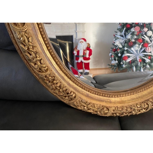 77 - A VERY FINE PAIR OF GILT OVAL SHAPED WALL MIRRORS, the mirrors with bevelled edge, the frames decora... 