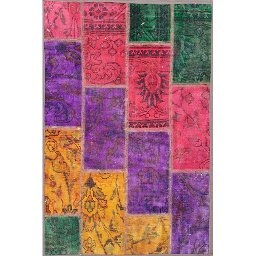 87 - A VIBRANT PERSIAN PATCHWORK RUG, featuring dyed patches of traditional Persian rugs in various desig... 