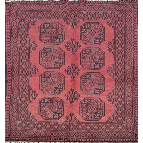 91 - A BEAUTIFUL TRADITIONAL AFGHAN AQCHA FLOOR RUG, with overall red ground colour, decorated with 8 med... 