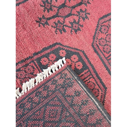 91 - A BEAUTIFUL TRADITIONAL AFGHAN AQCHA FLOOR RUG, with overall red ground colour, decorated with 8 med... 