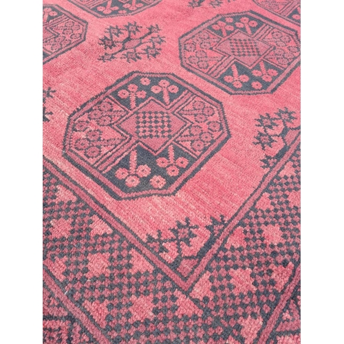 91 - A BEAUTIFUL TRADITIONAL AFGHAN AQCHA FLOOR RUG, with overall red ground colour, decorated with 8 med... 