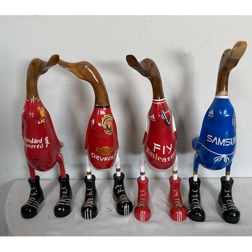 129 - A SET OF FOUR HARDWOOD DUCK FIGURINES, with painted soccer jerseys, dimensions: 50cm high approx.