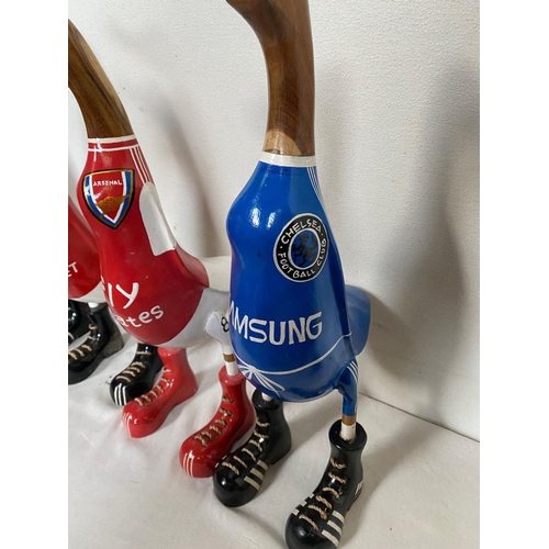 129 - A SET OF FOUR HARDWOOD DUCK FIGURINES, with painted soccer jerseys, dimensions: 50cm high approx.