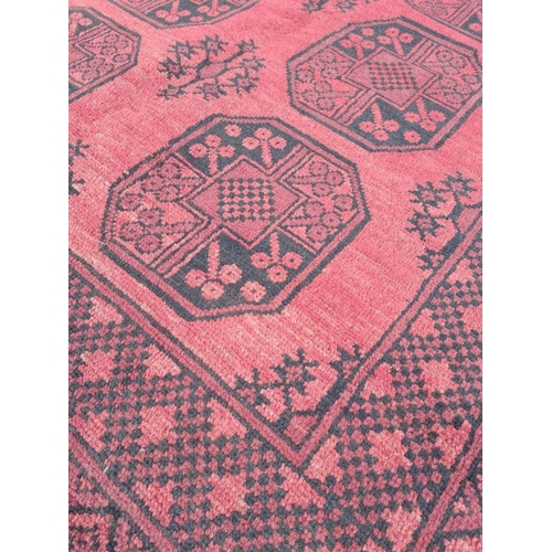140 - A BEAUTIFUL TRADITIONAL AFGHAN AQCHA FLOOR RUG, with overall red ground colour, decorated with 8 med... 