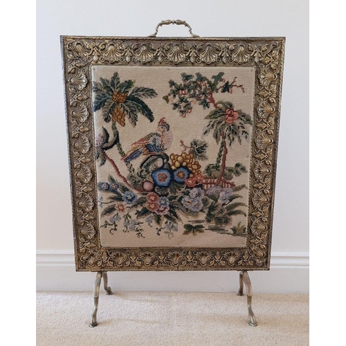 149 - AN ARTS N CRAFTS BRASS FRAMED FIRE SCREEN, the frame to the front with embossed floral & shell desig... 