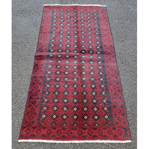 156 - A VERY GOOD QUALITY PERSIAN MASHAD BELOUCH FLOOR RUG, with a repeat diamond motif to the centre surr... 