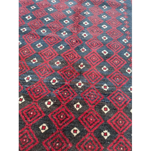 156 - A VERY GOOD QUALITY PERSIAN MASHAD BELOUCH FLOOR RUG, with a repeat diamond motif to the centre surr... 