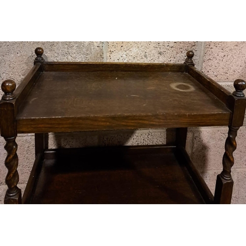 159 - AN ANTIQUE MAHOGANY DRINKS TROLLEY, with two tiers, twist supports with finials to top on castors. D... 