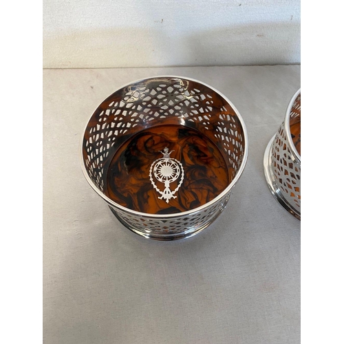 23 - A PAIR OF CIRCULAR SILVER PLATED WINE COASTERS, with pierced design surrounding, as well as inlaid t... 