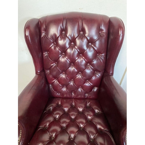 34 - A FINE RED LEATHER WINGBACK ARMCHAIR, button back with scroll armrests, standing on cabriole leg. Di... 