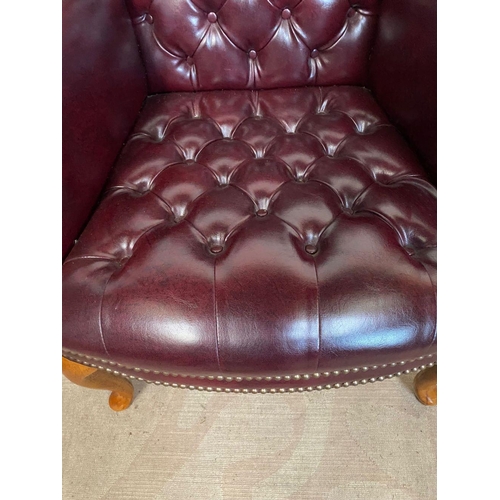 34 - A FINE RED LEATHER WINGBACK ARMCHAIR, button back with scroll armrests, standing on cabriole leg. Di... 