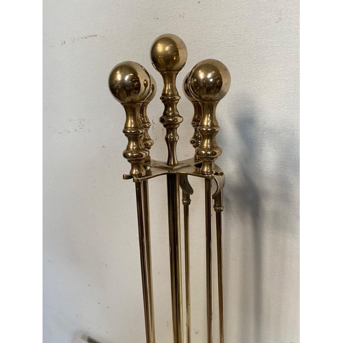 45 - A FINE BRASS FOUR PIECE FIRE SET ON STAND, to include shovel, poker, brush and tongs as well as stan... 