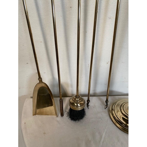 45 - A FINE BRASS FOUR PIECE FIRE SET ON STAND, to include shovel, poker, brush and tongs as well as stan... 