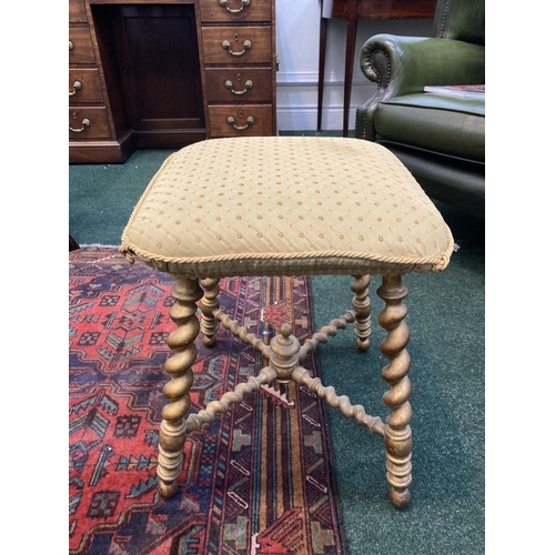 53 - A CHARMING 19TH CENTURY GILTWOOD BOBBIN STOOL, with cushioned upholstered seat, atop legs conjoined ... 