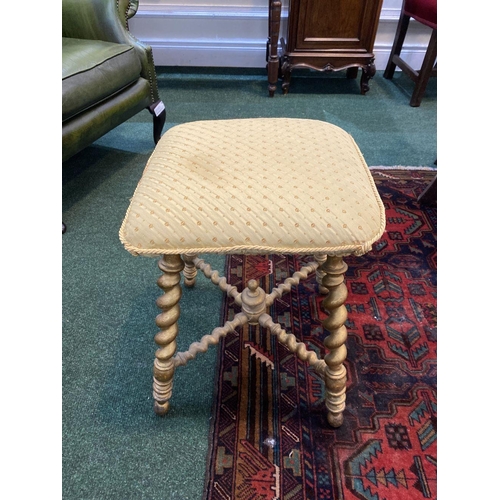 53 - A CHARMING 19TH CENTURY GILTWOOD BOBBIN STOOL, with cushioned upholstered seat, atop legs conjoined ... 