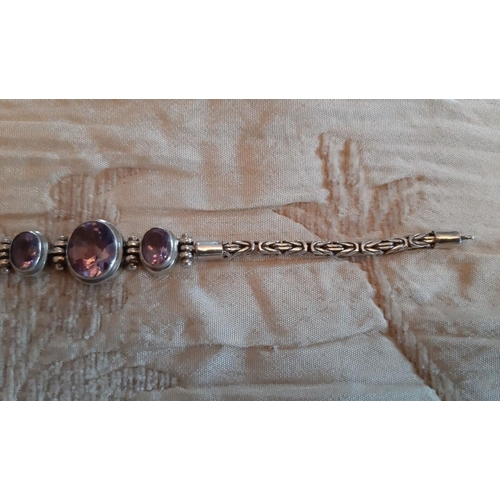 68 - A SILVER AND AMETHYST BRACELET, silver chain marked 925, set with three central stones, complete wit... 