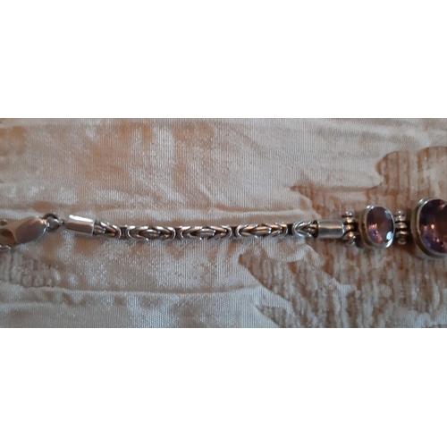 68 - A SILVER AND AMETHYST BRACELET, silver chain marked 925, set with three central stones, complete wit... 
