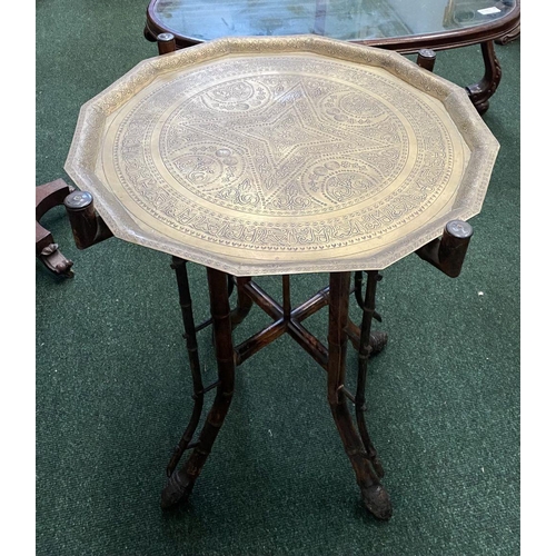 82 - AN ANTIQUE ANGLO/INDIAN FOLDING SIDE TABLE, decorative brass embossed shaped top with raised border,... 
