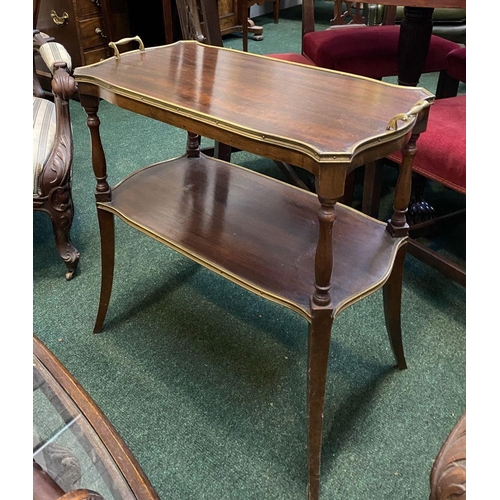 83 - AN ANTIQUE TWO TIER MAHOGANY SIDE TABLE, with gilt borders to shaped tiers, two handles, turned supp... 