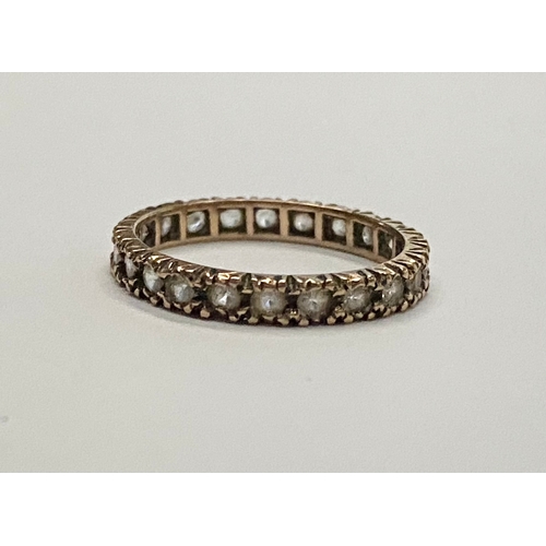 27 - A 9CT YELLOW GOLD ETERNITY RING, set with clear round cut stones in shared print setting. Ring Size:... 