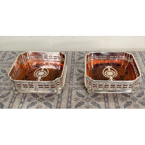 12 - A LOVELY PAIR OF SILVER PLATED WINE COASTERS, pierced design surrounding with tortoiseshell base dec... 