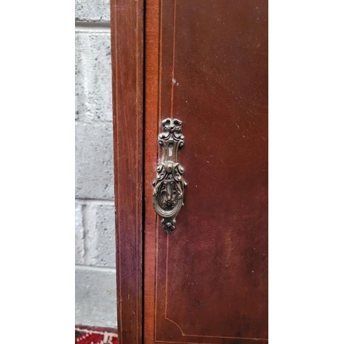 131 - A LATE 19th / EARLY 20TH CENTURY MAHOGANY STRING INLAID CABINET, with brass pull-ring handle to the ... 