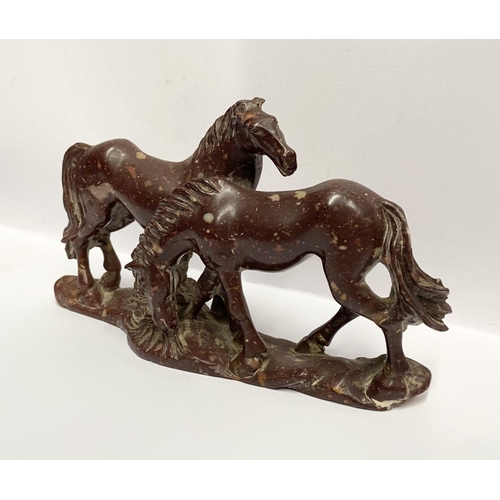 150 - AN ANTIQUE MOTTLED RED SOAPSTONE CARVING OF TWO HORSES, finely carved, on shaped soapstone base, dim... 