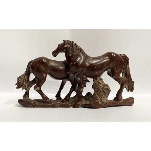 150 - AN ANTIQUE MOTTLED RED SOAPSTONE CARVING OF TWO HORSES, finely carved, on shaped soapstone base, dim... 