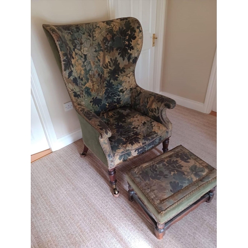 235 - A WINGBACK ARMCHAIR WITH MATCHING FOOTSTOOL, armchair with scroll armrests, upholstered with floral ... 