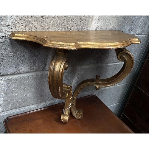 29 - A NAPOLEON III STYLE GILT DEMILUNE SHELF, with serpentine shaped top supported by carved scrolling l... 