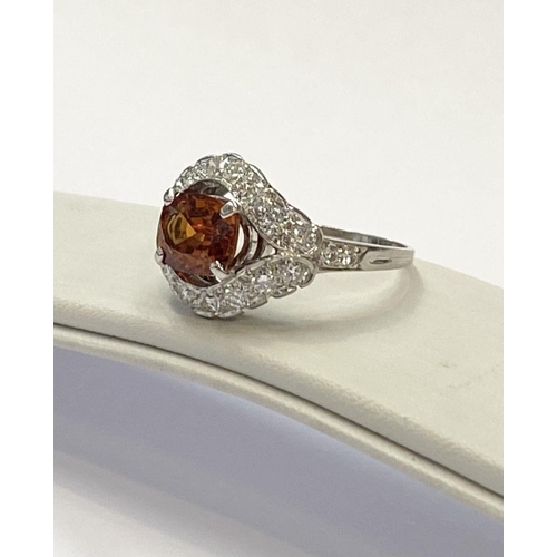 1 - AN EXCEPTIONAL ORANGE CITRINE AND DIAMOND WHITE GOLD CLUSTER RING, oval cut orange citrine in four p... 