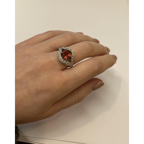 1 - AN EXCEPTIONAL ORANGE CITRINE AND DIAMOND WHITE GOLD CLUSTER RING, oval cut orange citrine in four p... 