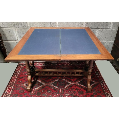 166 - AN EARLY 20TH CENTURY WALNUT & MAHOGANY FOLD OVER CARD TABLE, the top surface twists and folds open ... 