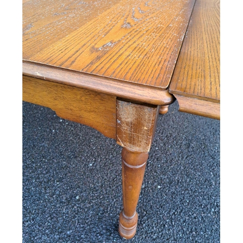 232 - A VINTAGE OAK DRAW-LEAF/EXTENDABLE DINING TABLE on turned legs; note damage to the finish on top of ... 