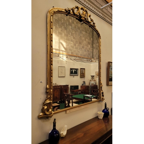 38 - A VERY FINE CARVED GILTWOOD WALL MIRROR / OVER MANTLE MIRROR, to the arch is a scrolling foliage car... 