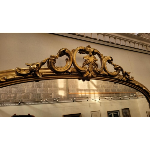 38 - A VERY FINE CARVED GILTWOOD WALL MIRROR / OVER MANTLE MIRROR, to the arch is a scrolling foliage car... 