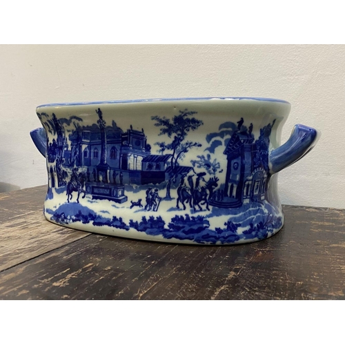 40 - AN IRONSTONE BLUE AND WHITE FOOTBATH/PLANTER, with painted scenes surrounding as well as to interior... 