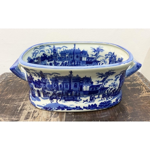 40 - AN IRONSTONE BLUE AND WHITE FOOTBATH/PLANTER, with painted scenes surrounding as well as to interior... 