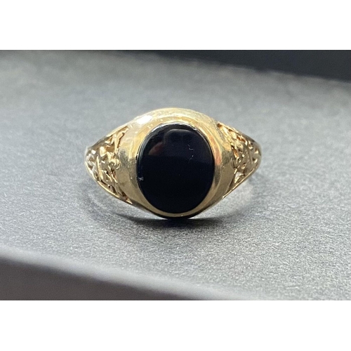 43 - A 9CT YELLOW GOLD ONYX RING, with decorative filigree to shoulders, Maker JJ, Marked 375, ring size:... 