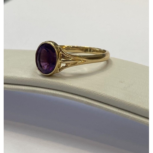 48 - AN ELEGANT 14CT YELLOW GOLD BEZEL AMETHYST RING, oval cut amethyst bezel set with split shank design... 